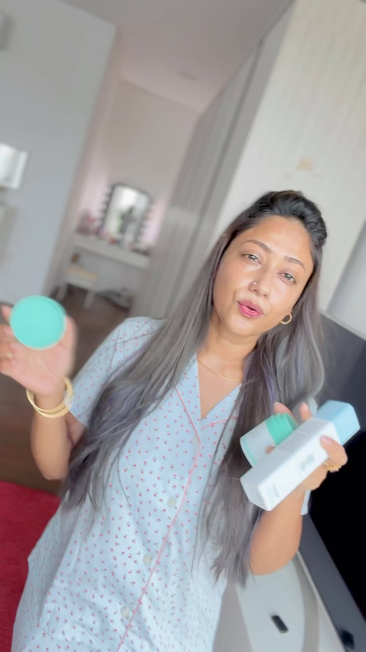 Woman holding eco-friendly skincare products in a modern room.